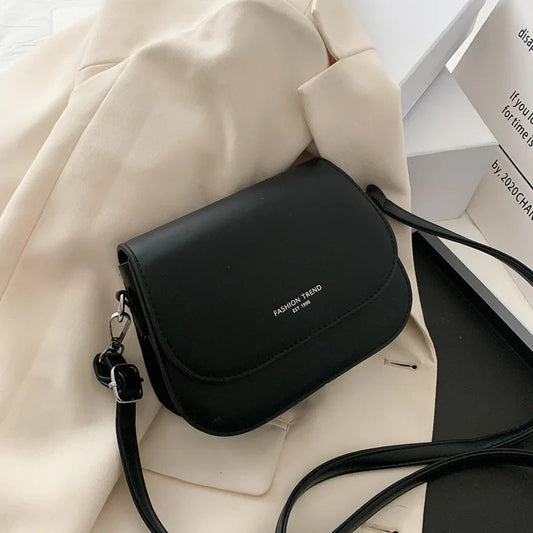 "Petit sac à main cuir beige Vogalia Paris posé sur table marbre avec accessoires féminins"