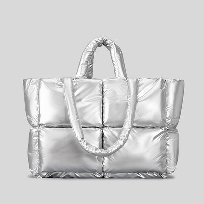 Femme portant sac matelassé duvet bronze en ville hiver, look cocooning fashion tendance
