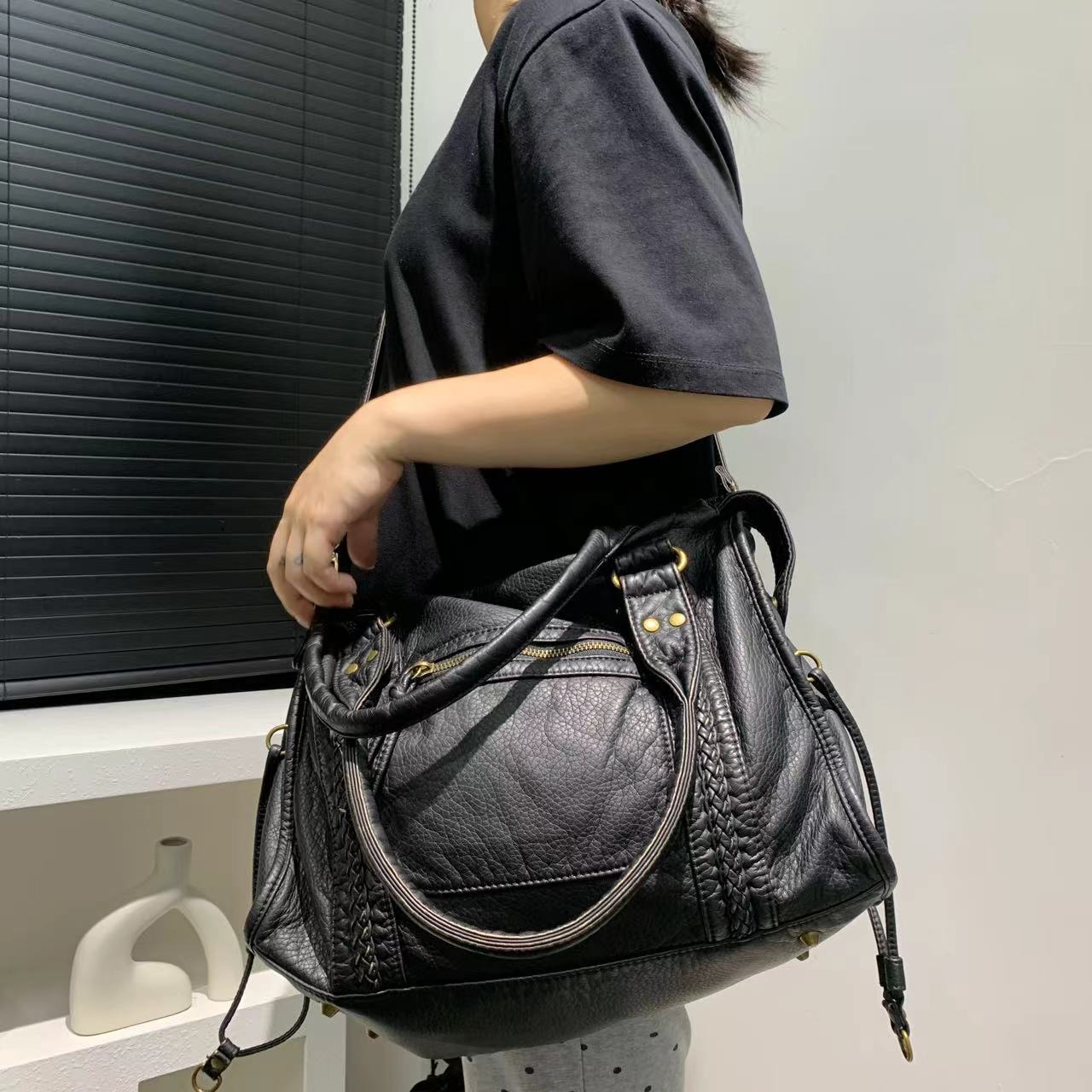 Gros plan matière PU souple sac messenger femme noir, texture lisse qualité premium
