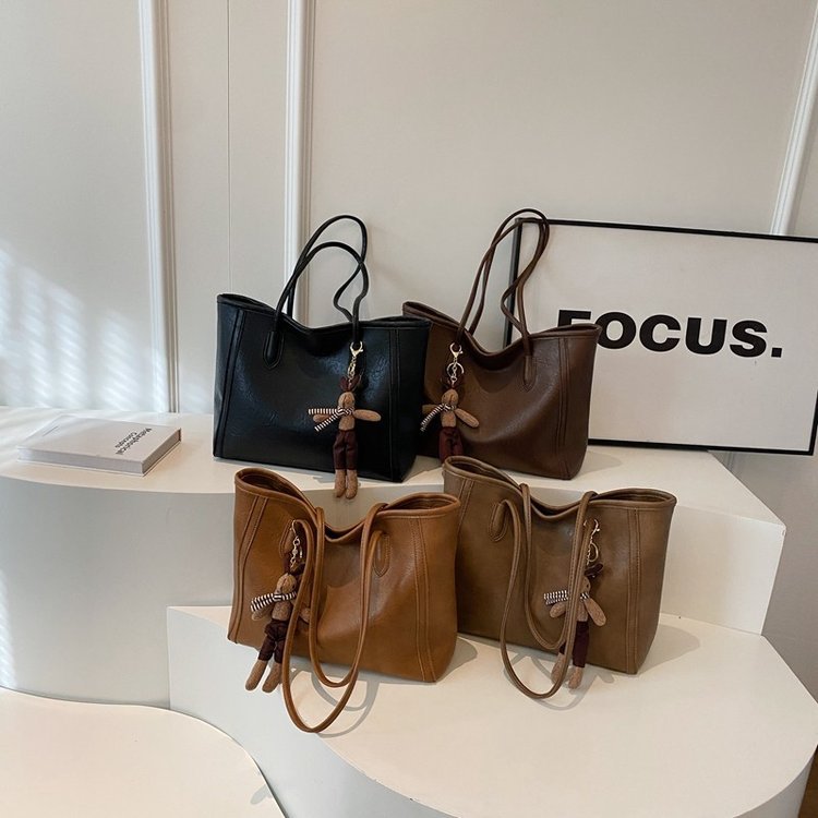 Femme portant le sac mixte avec pendentif look contemporain neutre