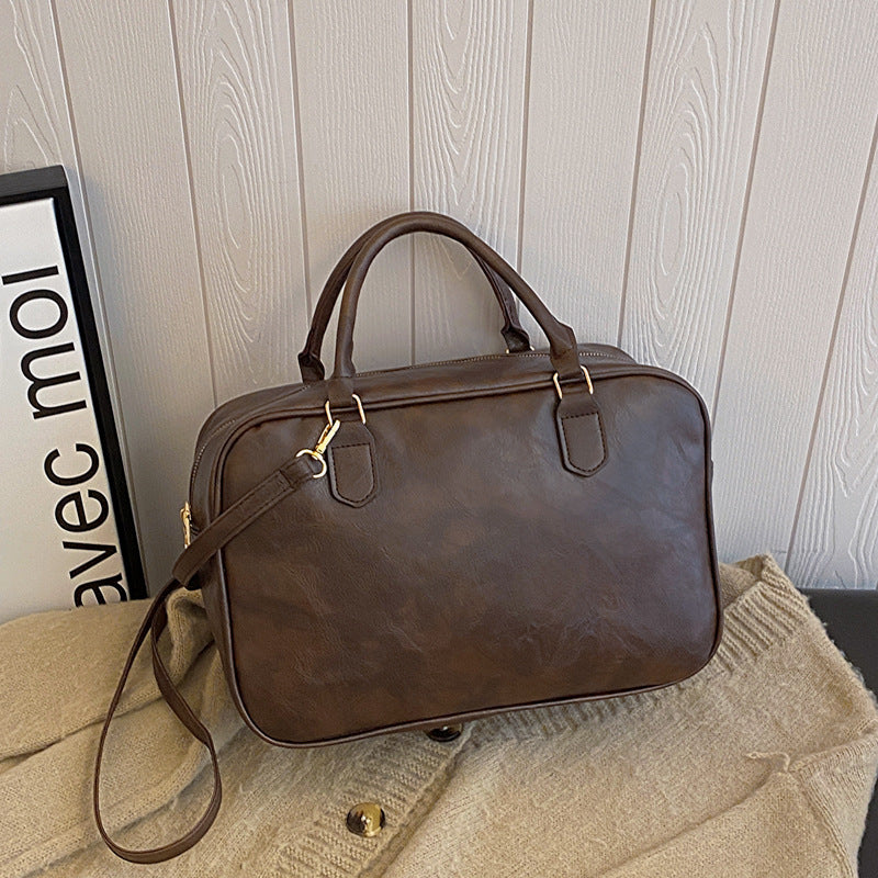 Vue frontale du sac carré femme avec fermeture éclair et finition cuir synthétique