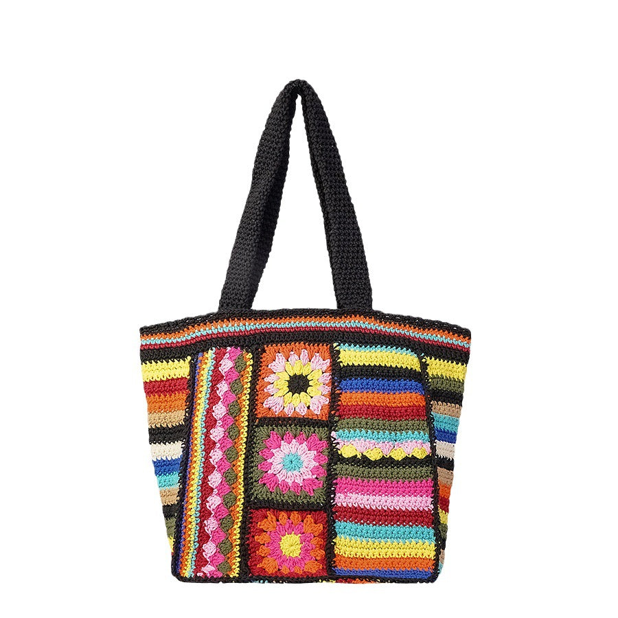 Gros plan broderie florale sac coton noir fait main, motif ethnique vintage artisanal détail fleurs
