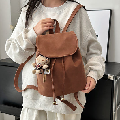 Femme portant sac à dos rétro marron nylon, look urbain casual vintage au quotidien